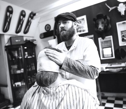 Barber cuts the customer’s hair